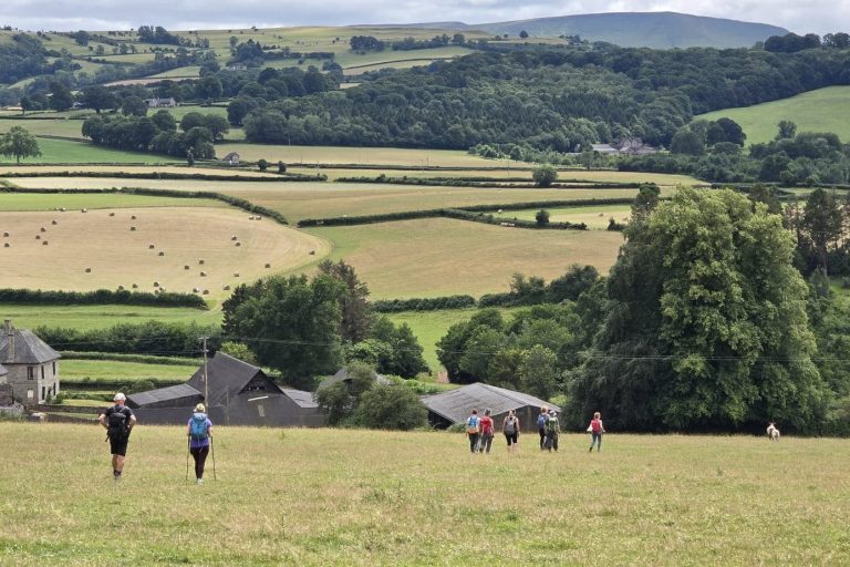 Walkers, walking across farm land towards farm buildings Walkers, walking across farm land towards farm buildings
