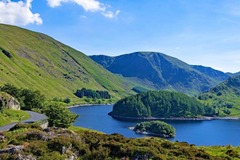 View over Haweswater Reservoir, huge green mountains around side. 